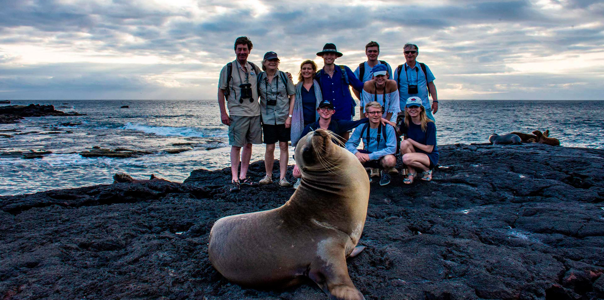 Grupo de amigos posando con un lobo marino de Galápagos