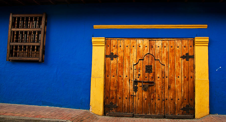 Blue wall and colonial style doors in La Candelaria neighborhood Bogota, Colombia