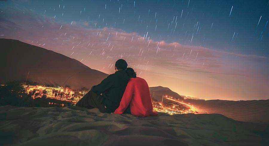 Couple admiring the stars in Huacachina, Peru