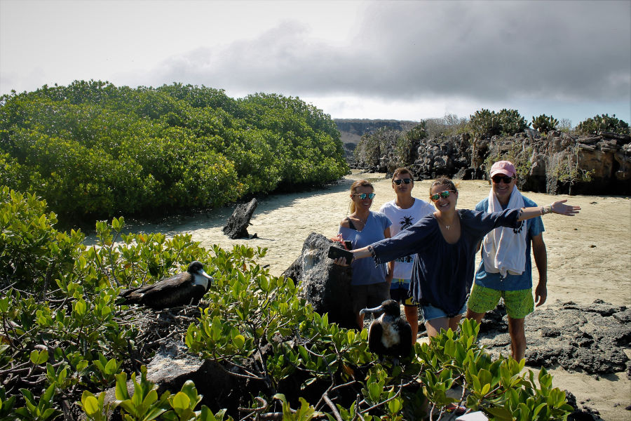 Visitantes posan junto a unas fragatas en Galápagos