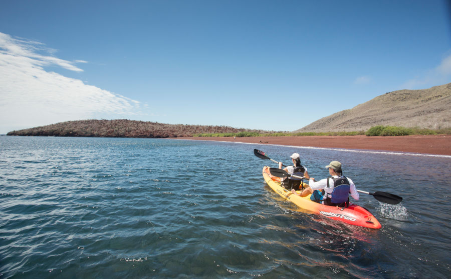 Visitors explore the coast of Rabida Island on a Kayak in the Galapagos