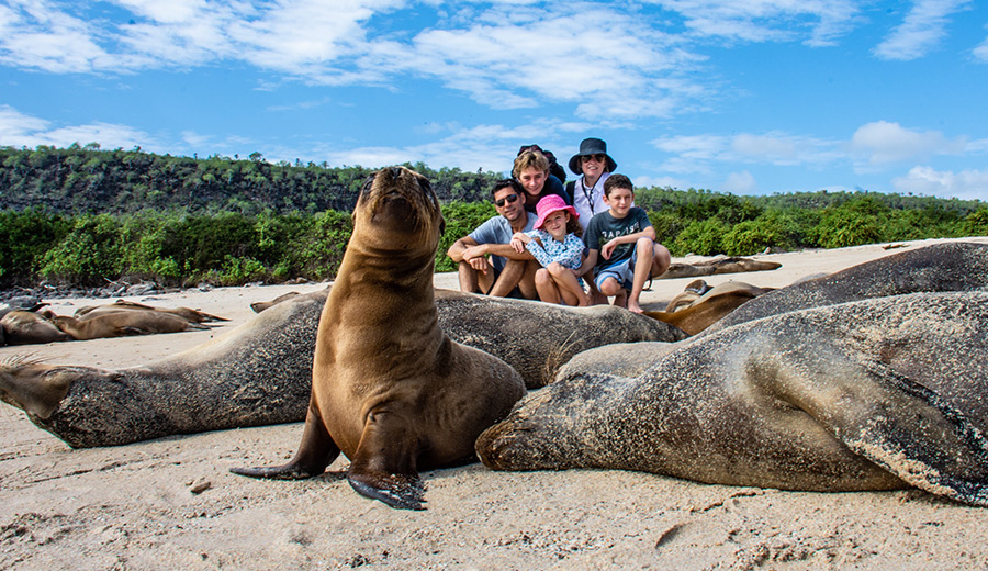 Familia posando con un Lobo marino de Galápagos