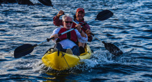 Senior travelers kayaking in Gardner Bay, Galapagos